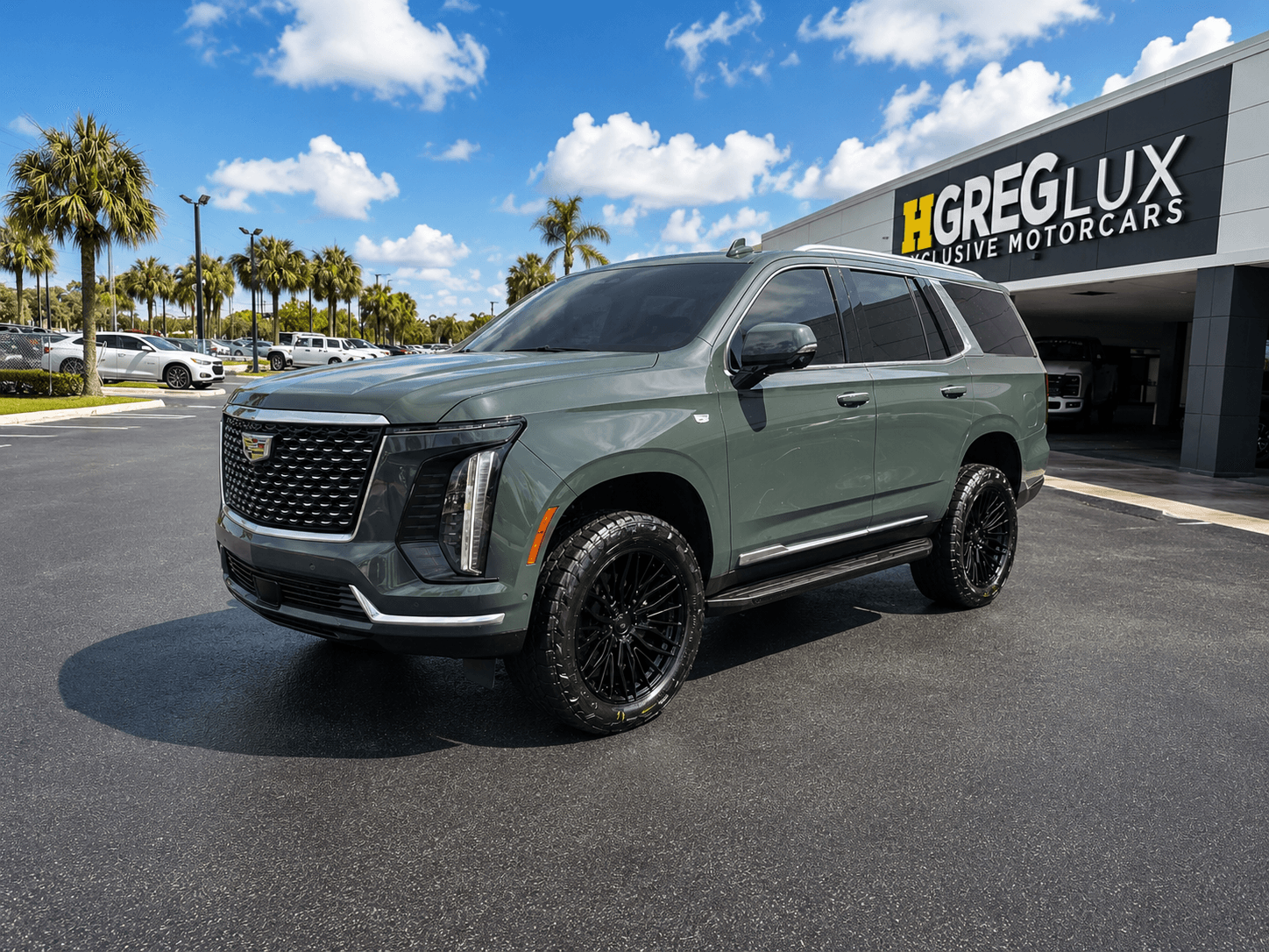 The HGreg Lux building at 551 S Military Trl, home of HGreg Lifted, with a lifted Cadillac Escalade out front