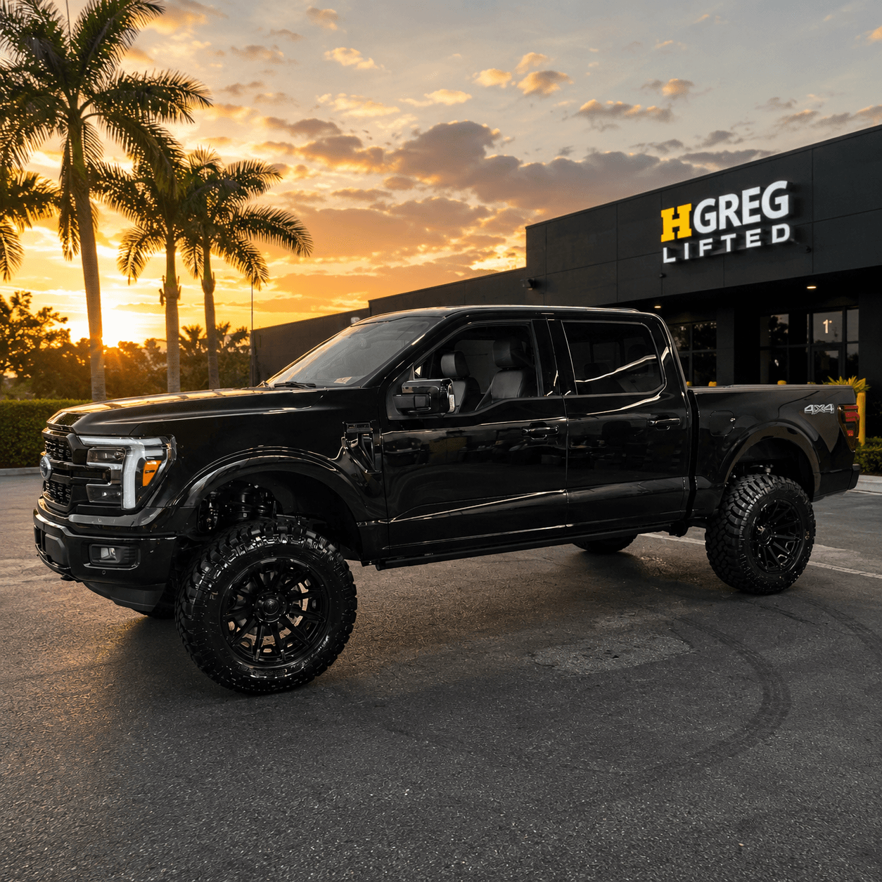 Lifted black Ford F-150 built by HGreg Lifted, outside the shop at sunset